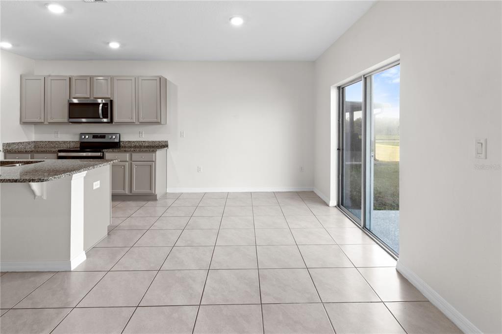 2651 Grandbury Grove Road Lakeland, FL 33811 - Photo 5 of 41 a kitchen with stainless steel appliances a sink a stove a microwave and cabinets