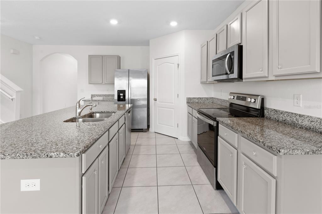 2651 Grandbury Grove Road Lakeland, FL 33811 - Photo 6 of 41 a kitchen with stainless steel appliances granite countertop a sink stove and cabinets