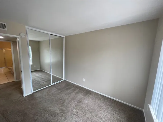 an empty room with closet and mirror