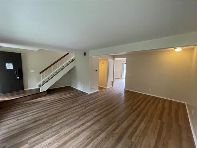 a big room with wooden floor and natural light