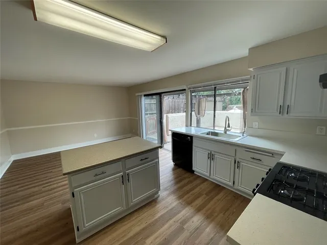a kitchen with a sink window and cabinets
