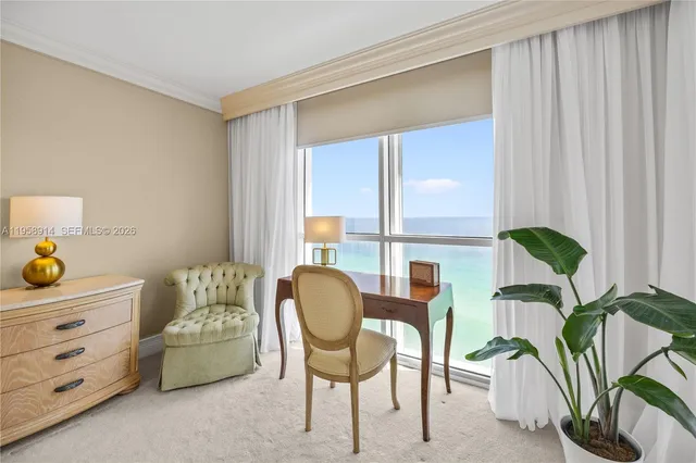 a dining room with furniture and a floor to ceiling window