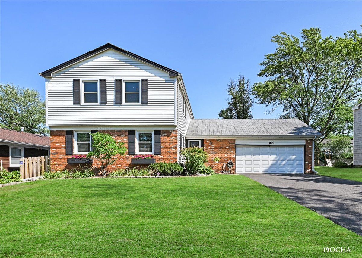 165 Stonegate Road Buffalo Grove, IL 60089 - Photo 1 of 25 a front view of a house with garden