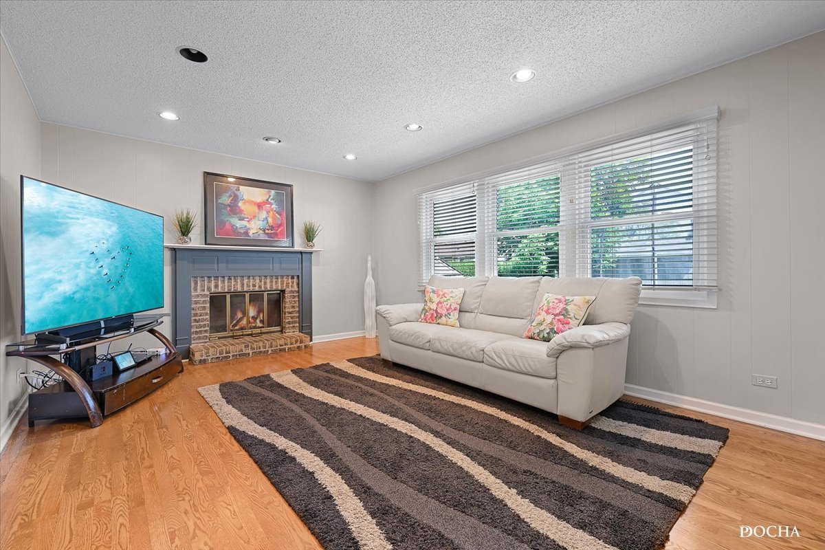 165 Stonegate Road Buffalo Grove, IL 60089 - Photo 13 of 25 a living room with furniture a flat screen tv and a fireplace