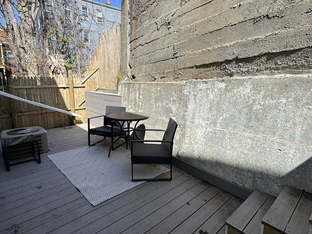 5 St James Place, Unit 5 Boston, MA 02119 - Photo 7 of 12 a balcony with wooden floor and glass door