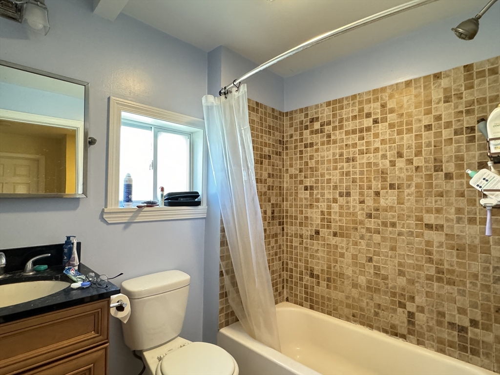 5 St James Place, Unit 5 Boston, MA 02119 - Photo 8 of 12 a bathroom with a toilet a sink and a shower