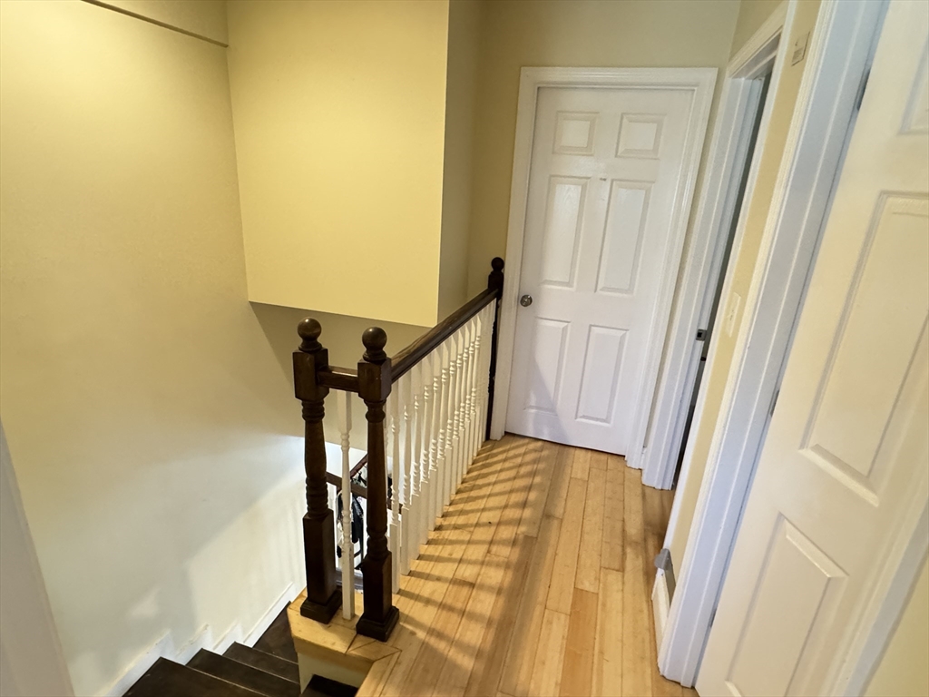 5 St James Place, Unit 5 Boston, MA 02119 - Photo 9 of 12 a view of a hallway with wooden floor and stairs