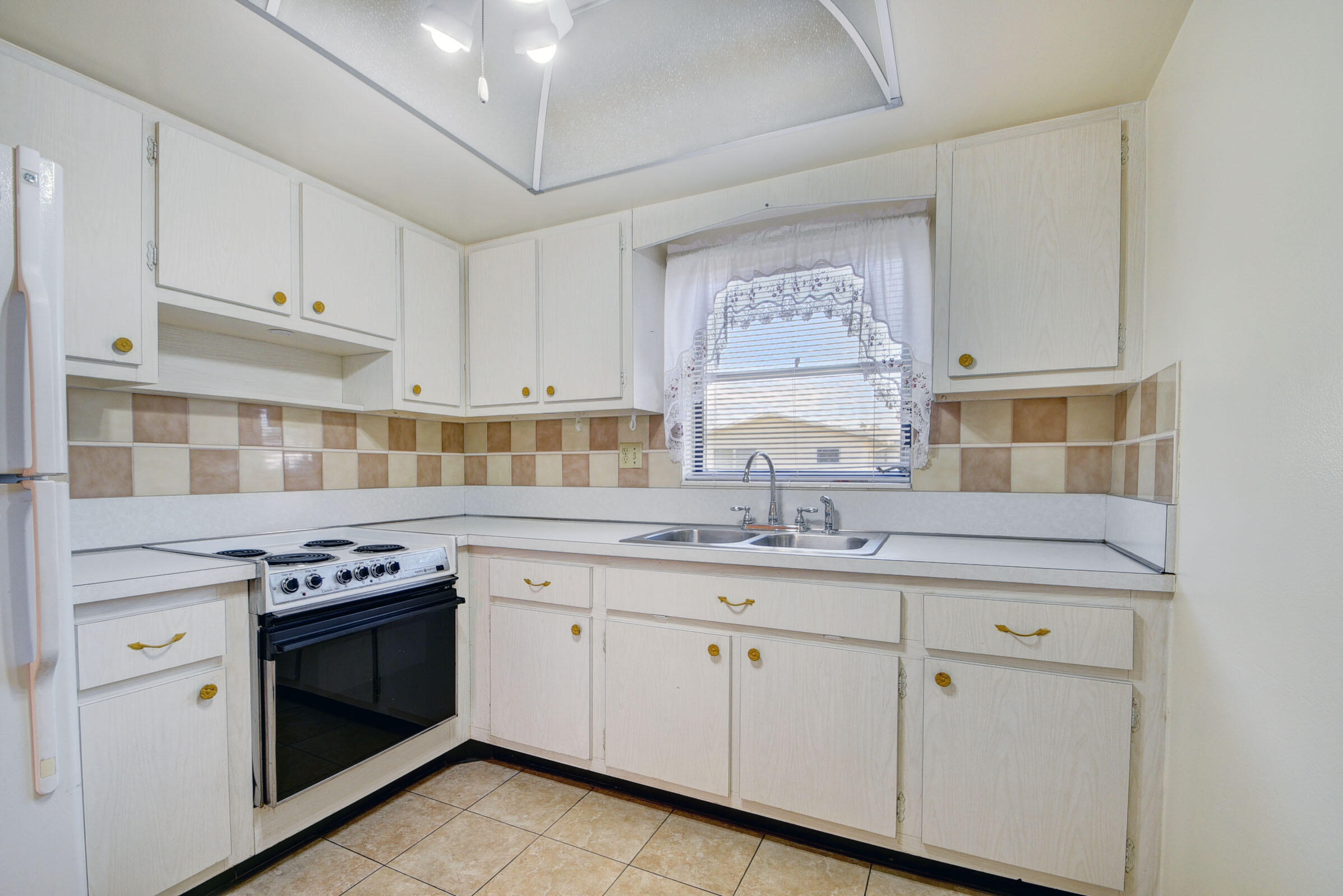 a kitchen with cabinets appliances a sink and a window