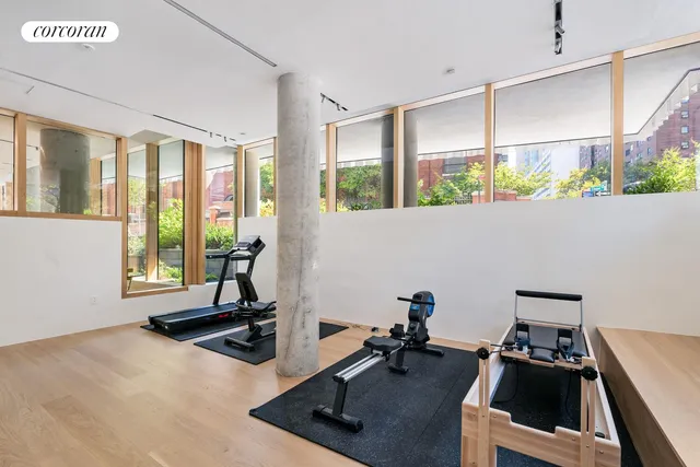 a room with gym equipment and large windows