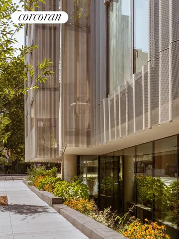 a front view of a building with glass windows and a bench