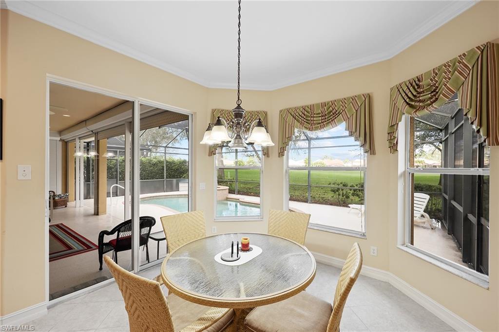 6921 Bent Grass Drive Naples, FL 34113 - Photo 15 of 48 a dining room with furniture a chandelier and glass door