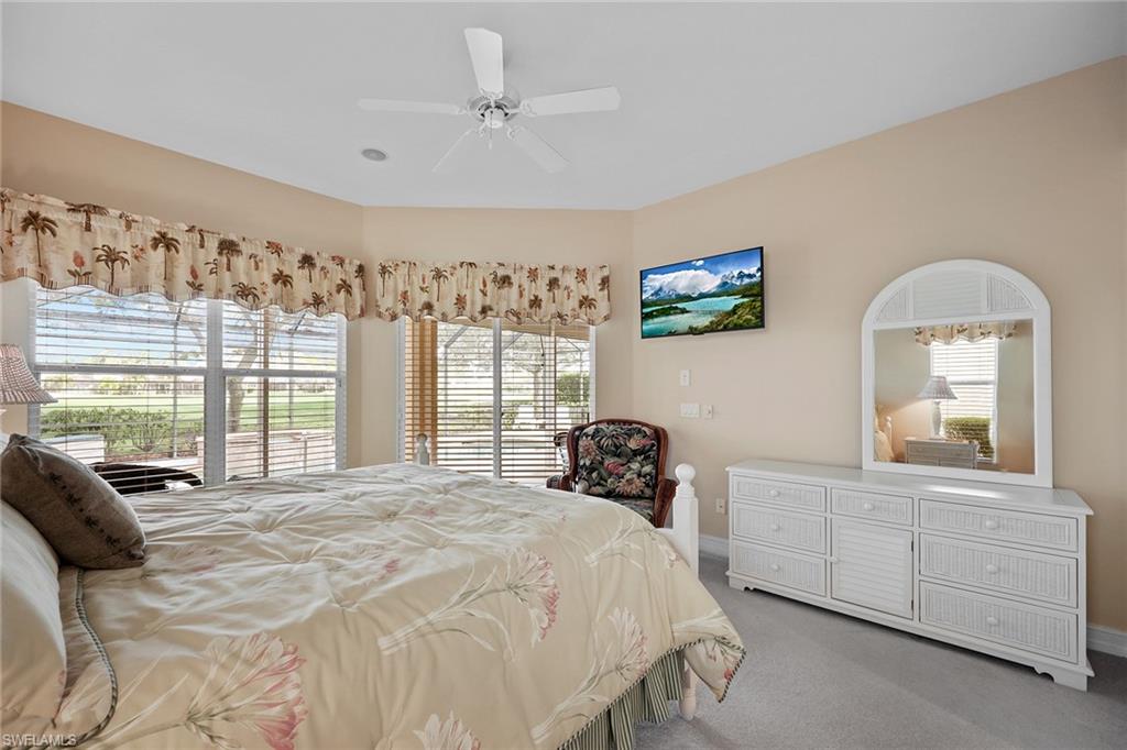 6921 Bent Grass Drive Naples, FL 34113 - Photo 17 of 48 a bedroom with a bed a dresser and a large window