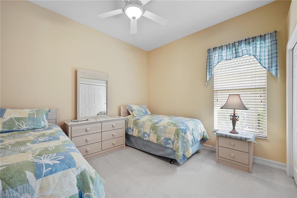 6921 Bent Grass Drive Naples, FL 34113 - Photo 20 of 48 a bedroom with a bed and a chandelier