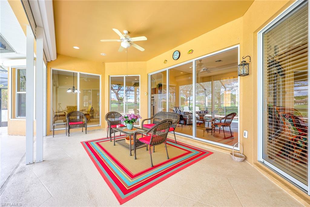 6921 Bent Grass Drive Naples, FL 34113 - Photo 24 of 48 a living room with furniture a rug and a floor to ceiling window