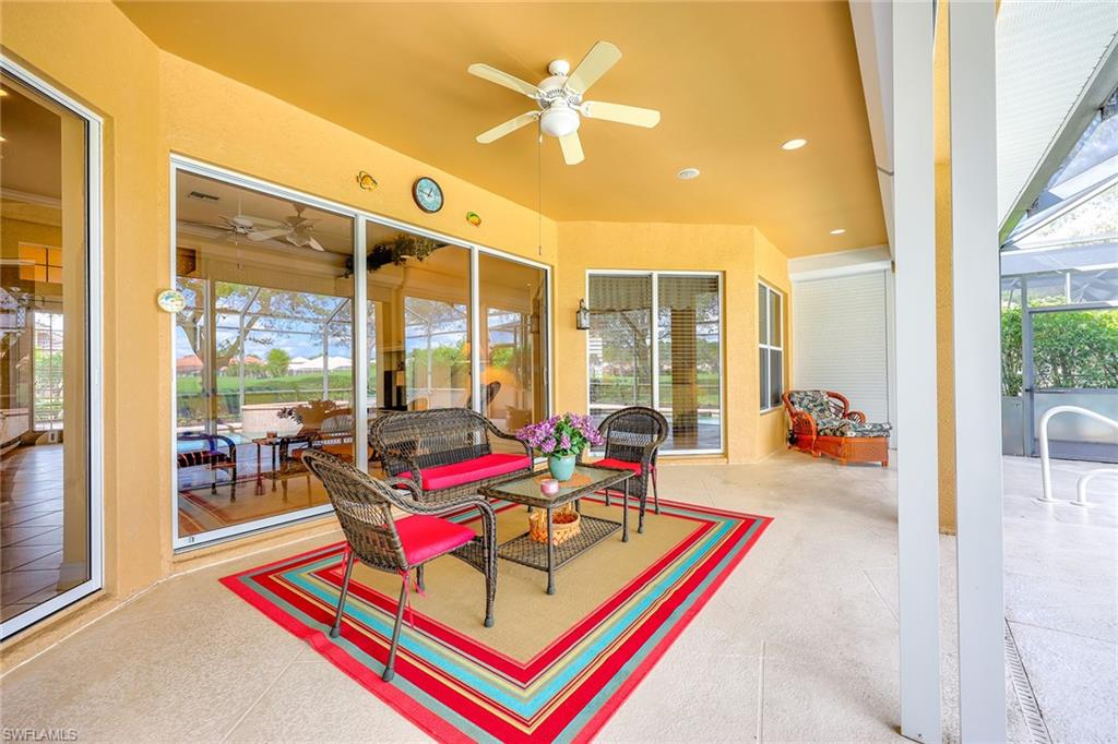 6921 Bent Grass Drive Naples, FL 34113 - Photo 25 of 48 a living room filled with furniture and a chandelier