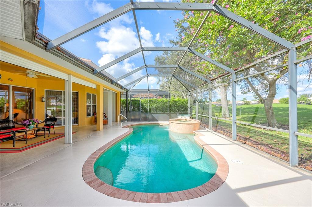 6921 Bent Grass Drive Naples, FL 34113 - Photo 26 of 48 a view of a swimming pool with a patio