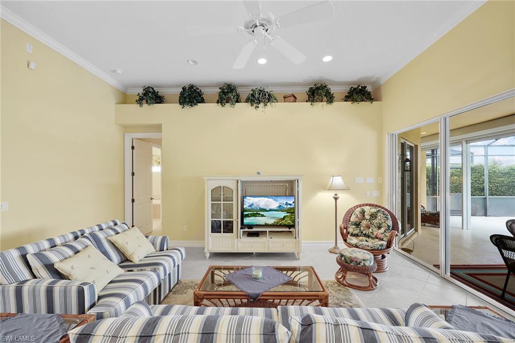 6921 Bent Grass Drive Naples, FL 34113 - Photo 9 of 48 a living room with furniture and a floor to ceiling window