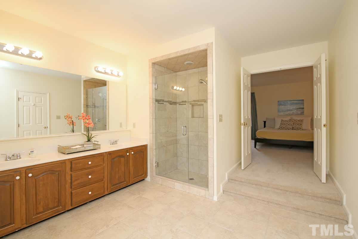 2416 Constitution Drive Raleigh, NC 27615 - Photo 16 of 25 a view of a bathroom with double vanity sink and mirror