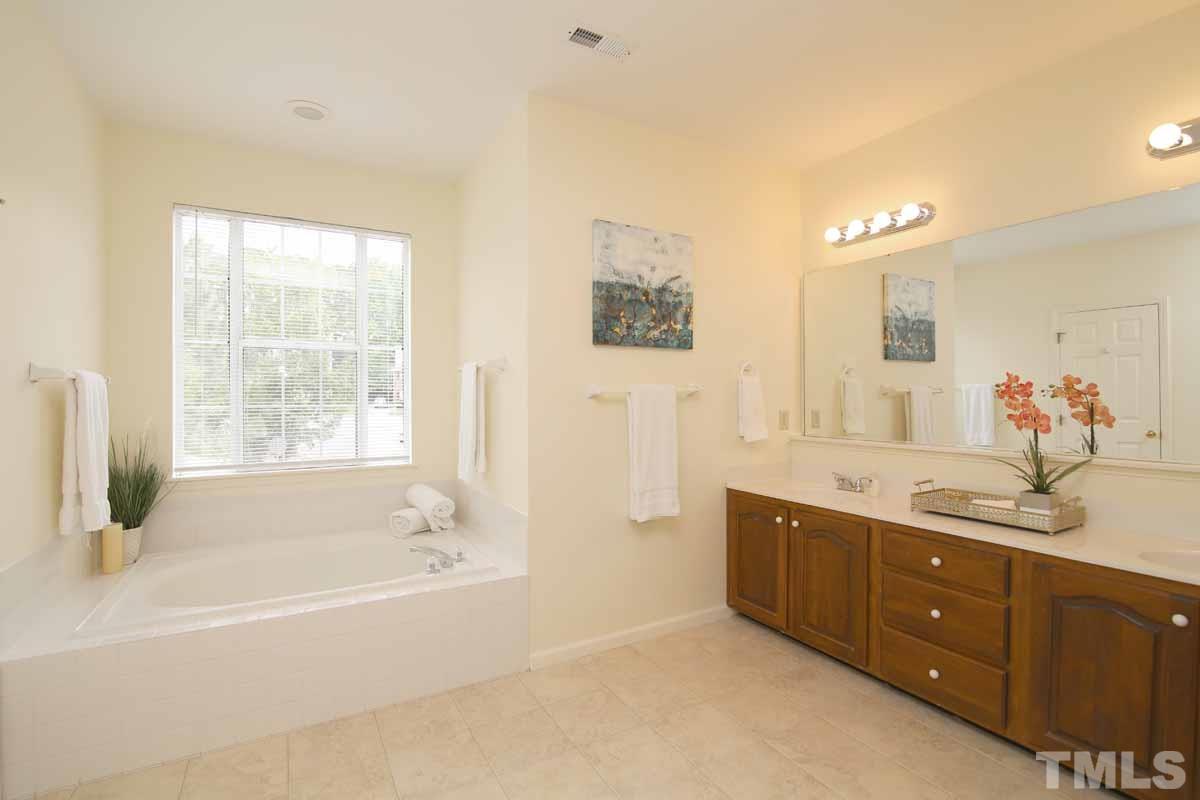 2416 Constitution Drive Raleigh, NC 27615 - Photo 17 of 25 a spacious bathroom with a tub sink and mirror