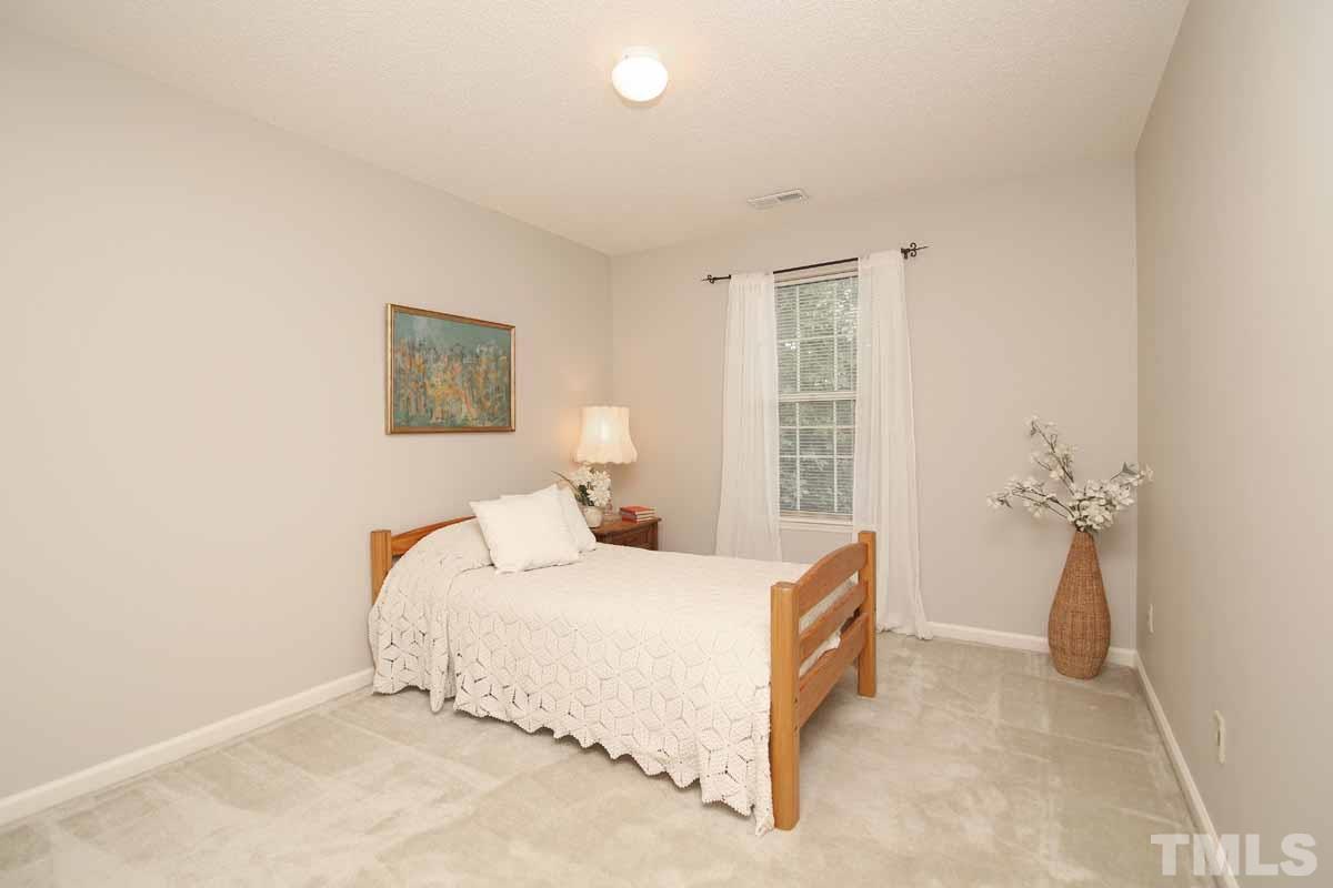 2416 Constitution Drive Raleigh, NC 27615 - Photo 19 of 25 a bedroom with a bed and a table