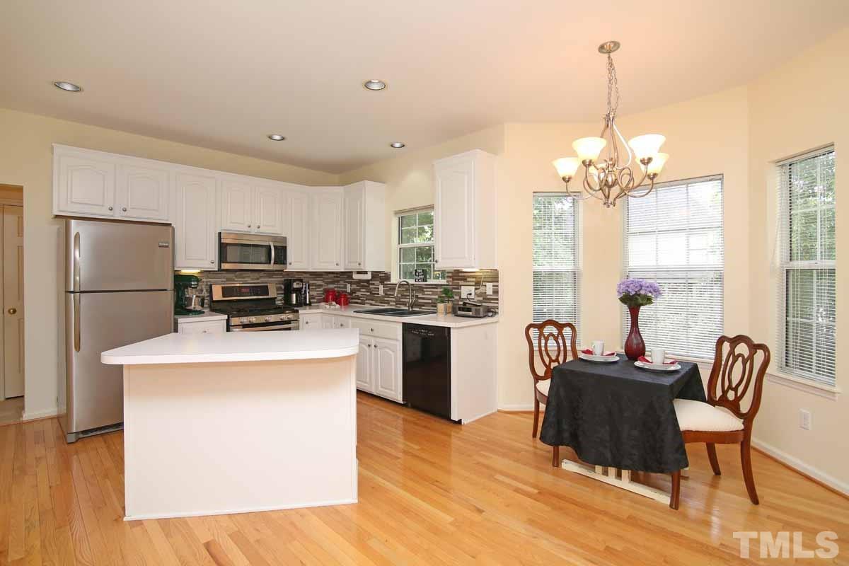 2416 Constitution Drive Raleigh, NC 27615 - Photo 3 of 25 a kitchen that has a refrigerator a stove a dining table and chairs