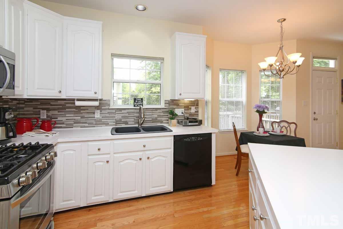 2416 Constitution Drive Raleigh, NC 27615 - Photo 4 of 25 a kitchen with stainless steel appliances sink stove and cabinets