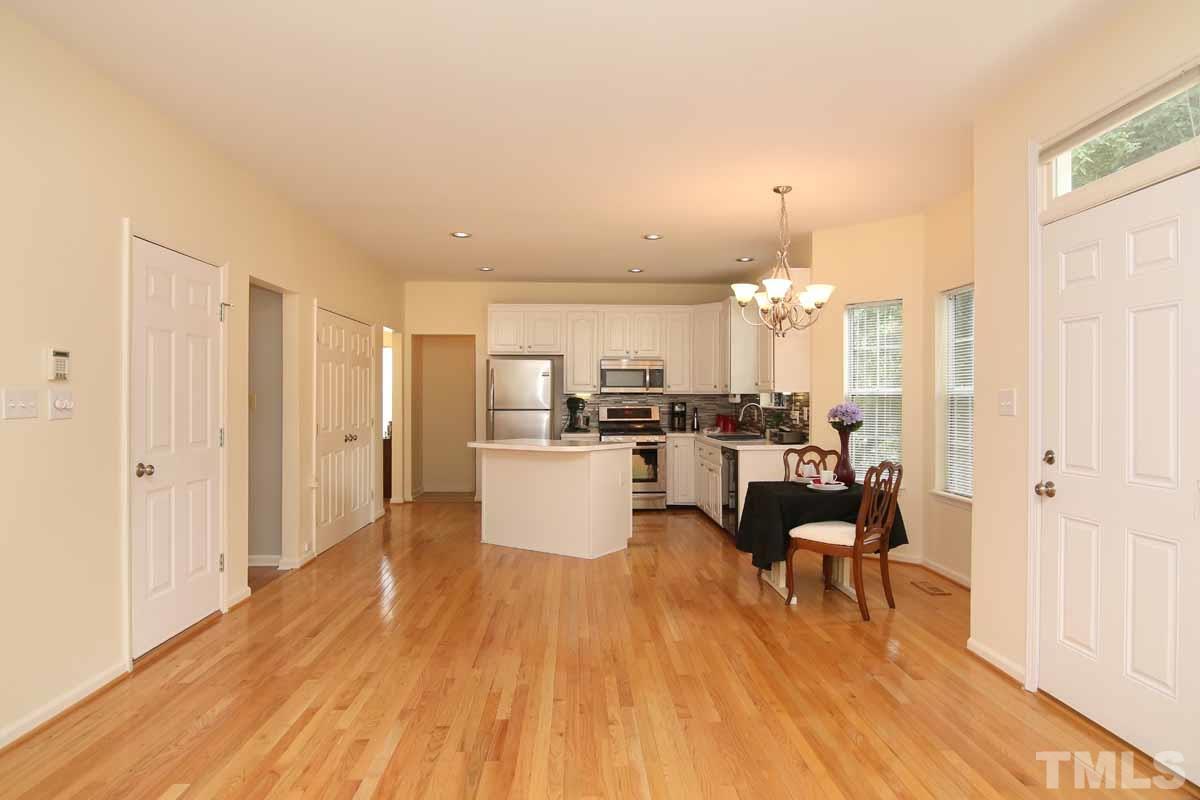 2416 Constitution Drive Raleigh, NC 27615 - Photo 6 of 25 a living room with couches and kitchen view with wooden floor
