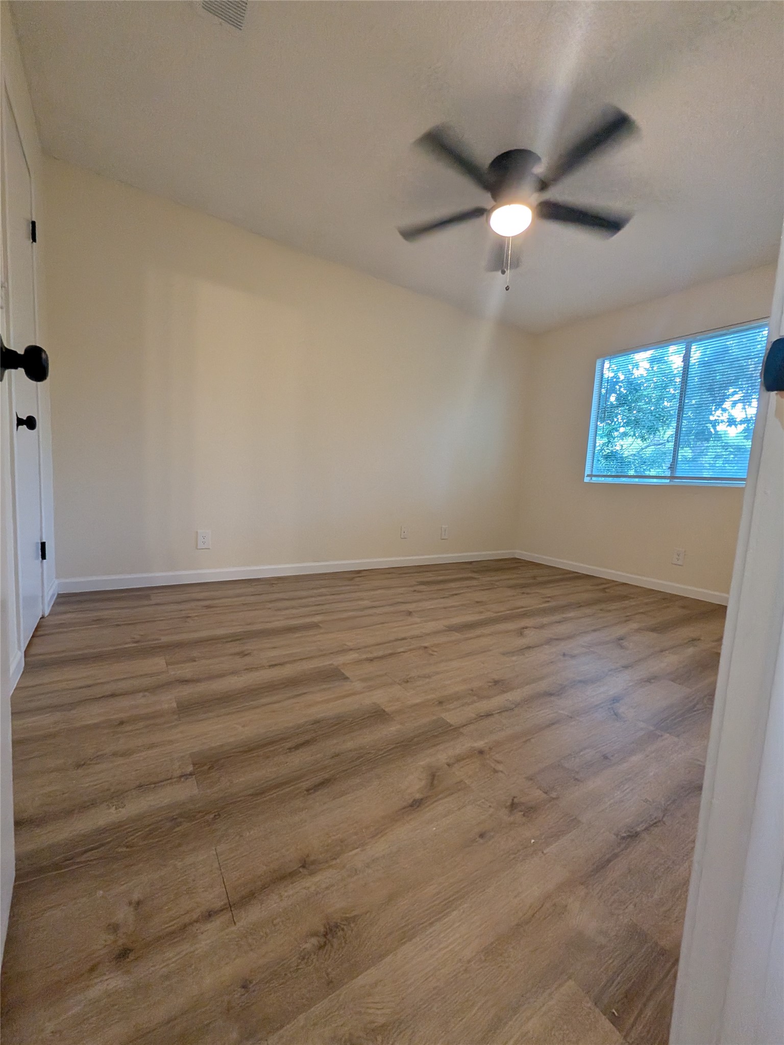 13303 Lyndhurst Street, Unit B Austin, TX 78729 - Photo 12 of 13 A quiet bedroom featuring resilient laminate flooring and a ceiling fan for year-round comfort.