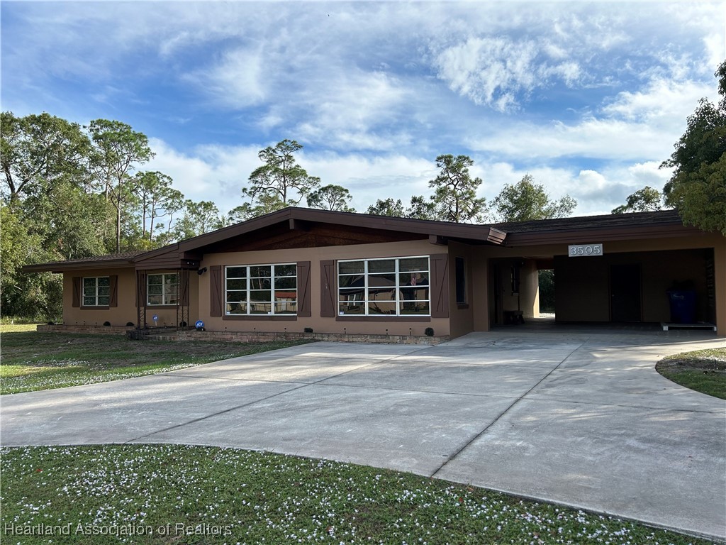 3505 Golfview Road Sebring, FL 33875 - Photo 28 of 50 a front view of a house with a garden and trees
