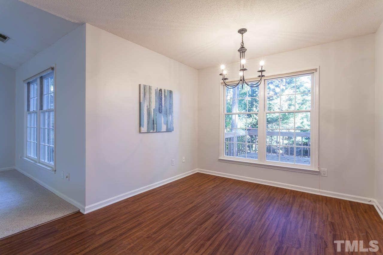 11916 North Exeter Way Raleigh, NC 27613 - Photo 14 of 25 a view of an empty room with wooden floor and a window