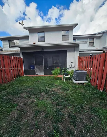 a view of a chair and table in back yard of the house