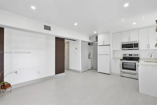 a view of kitchen with refrigerator and microwave