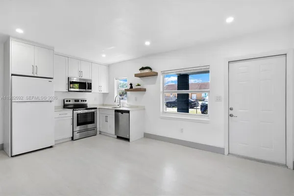 a kitchen with stainless steel appliances a refrigerator sink and microwave