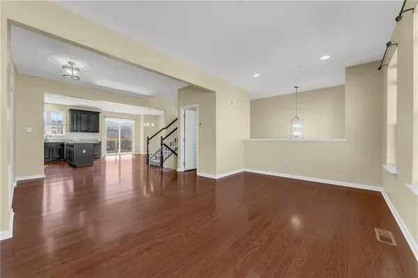 a view of empty room with wooden floor and a window
