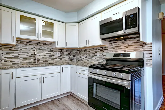 a kitchen with cabinets stainless steel appliances and a sink