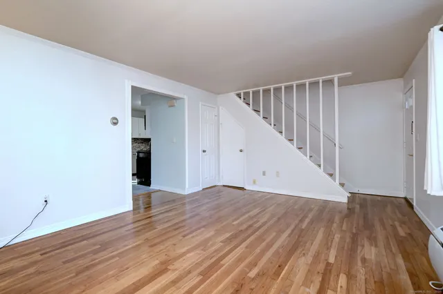 a view of an empty room with wooden floor