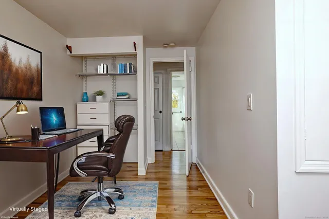a view of a workspace with furniture and wooden floor