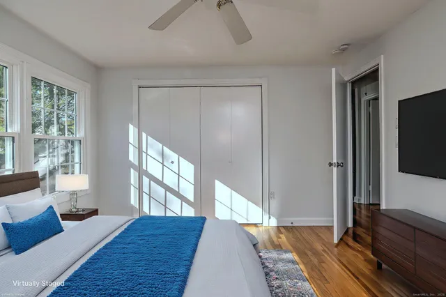 a bedroom with a bed and a flat tv screen on a dresser