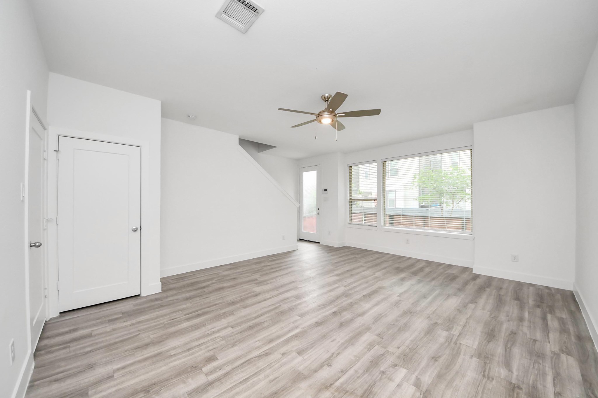 18527 Centro Row Conroe, TX 77385 - Photo 7 of 44 Sunlight pours through the glass-paneled door and broad windows, dancing across the premium luxury vinyl plank floors of this adaptable first-floor space.