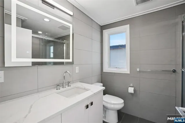 a bathroom with a sink a toilet and a window