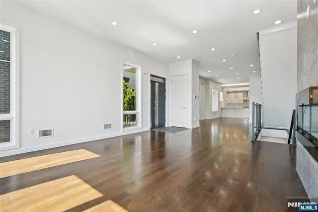 a view of a big room with wooden floor and windows