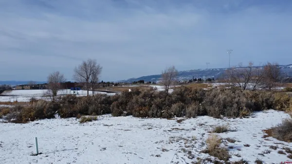 a view of a dry yard covered with snow on the road