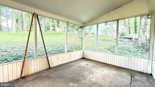 a view of an empty room with wooden floor and door