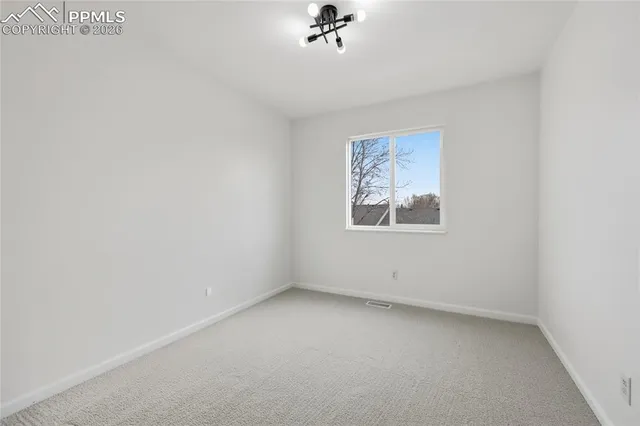 an empty room with a cabinet and a window