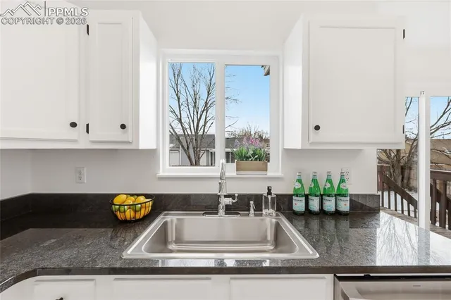 a kitchen with granite countertop a sink a stove and a granite counter tops