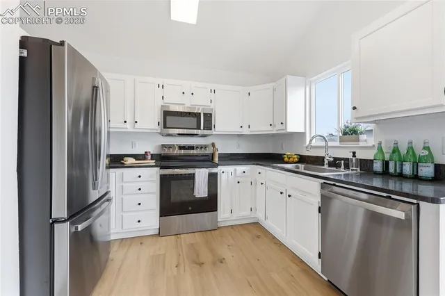 a kitchen with stainless steel appliances a refrigerator sink and cabinets