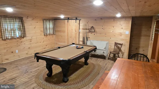 a room with pool table and windows