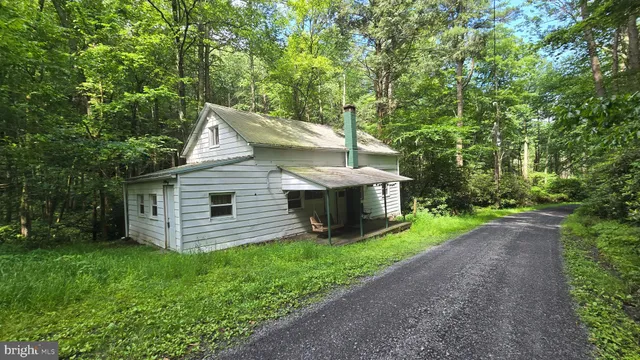 a view of a house with a yard and large trees