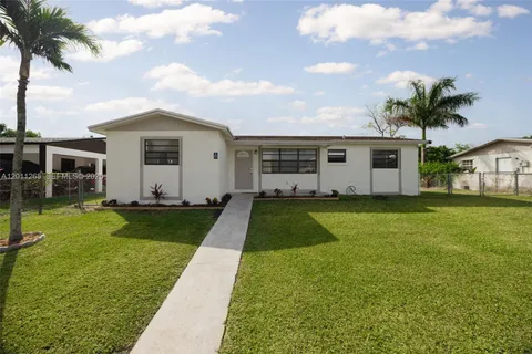 a front view of house with yard and swimming pool
