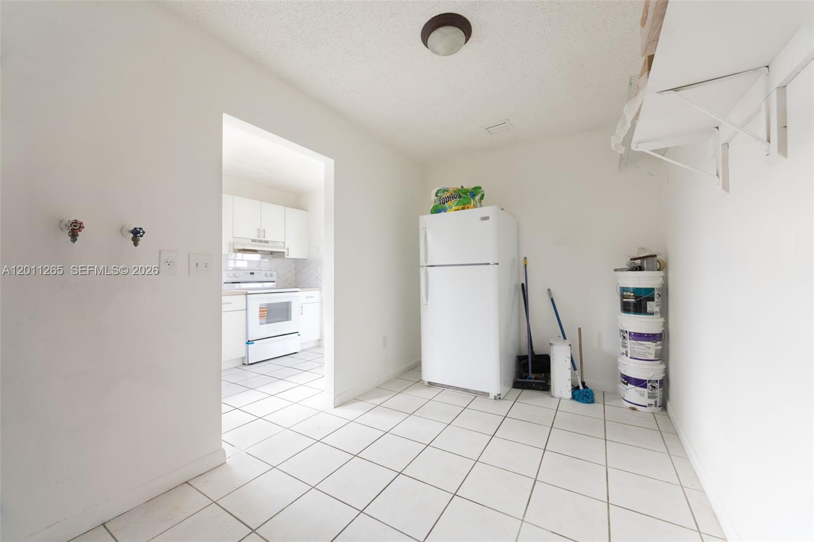 29935 Southwest 143rd Court Homestead, FL 33033 - Photo 10 of 25 a view of a storage & utility room with refrigerator and toys